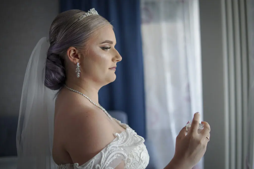 Braut in weißem Kleid am fertig machen - Hochzeitsfotografie Studio Alex